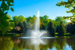 A pond fountain with a central stream and side jets creating a spray pattern in a pond, with trees in the background.