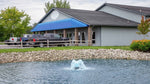 Building with a pond in front, cars parked outside