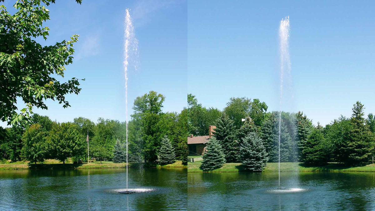 A jet stream fountain producing a high vertical spray in a pond, with trees in the background.